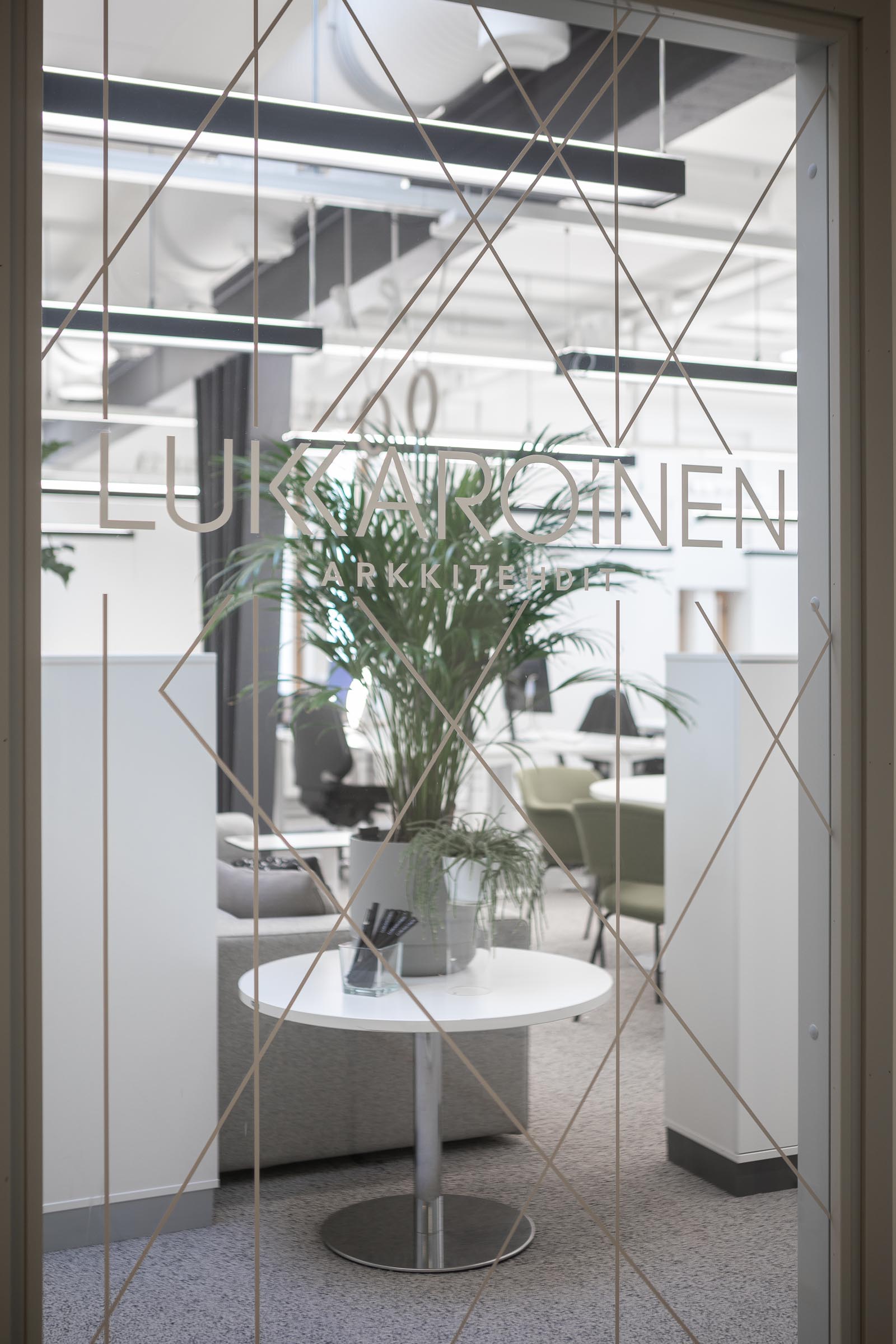 Lukkaroisen Oulun toimiston uudistetut tilat, näkymä lasiseinän läpi toimistoon.